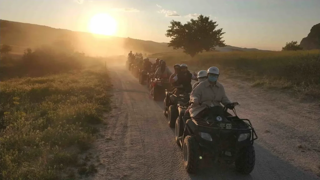 ATV riders following a dusty Cappadocia trail at sunset