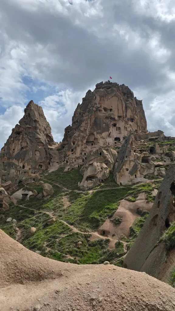 Uchisar Castle carved into a rocky peak under dramatic clouds