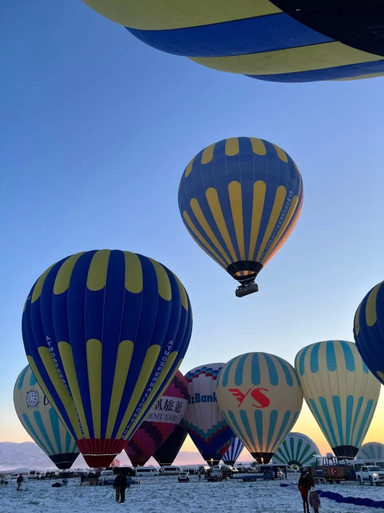 Hot air balloons preparing to fly over snowy Cappadocia